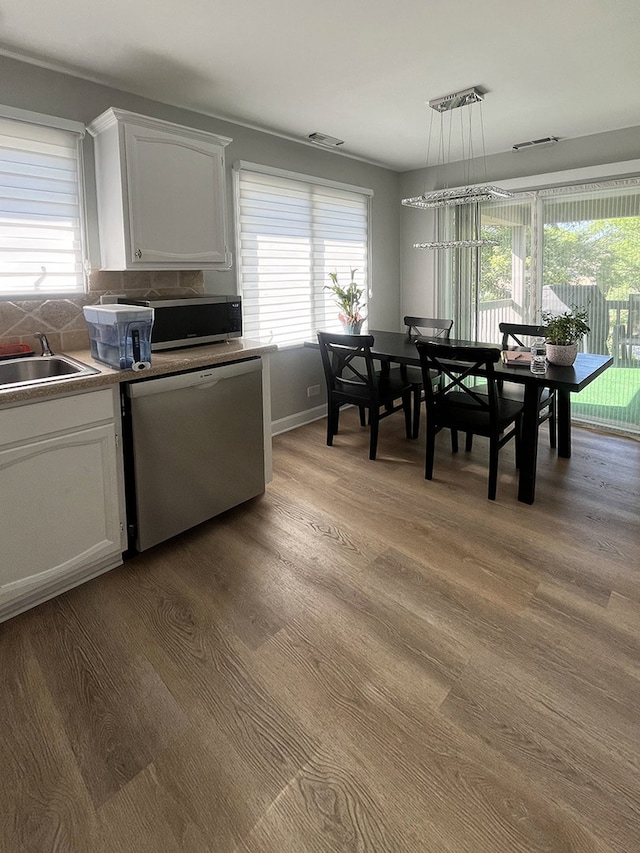 985 W Ct Unit D, Naperville, IL 60563 - kitchen featuring stainless steel dishwasher, healthy amount of natural light, and white cabinetry