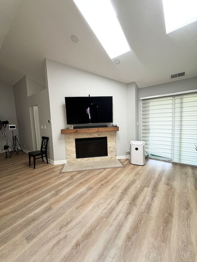 985 W Ct Unit D, Naperville, IL 60563 - living area with wood finished floors, vaulted ceiling, baseboards, and a tile fireplace