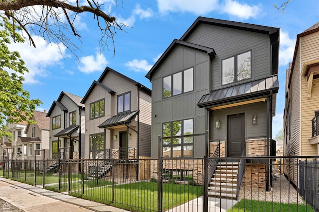 3903 N Drake Ave, Chicago, IL 60618 - modern home featuring a standing seam roof, a fenced front yard, a gate, and board and batten siding