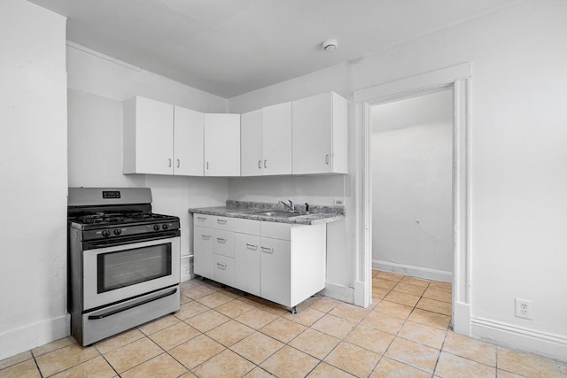 2022 S Halsted St, Chicago Heights, IL 60411 - kitchen featuring stainless steel range with gas stovetop, white cabinetry, a sink, and light tile patterned flooring