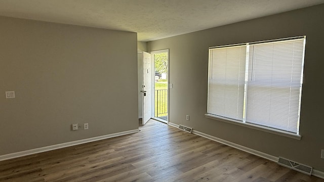 1117 Cutter Ave, Joliet, IL 60432 - empty room featuring baseboards, wood finished floors, and a textured ceiling