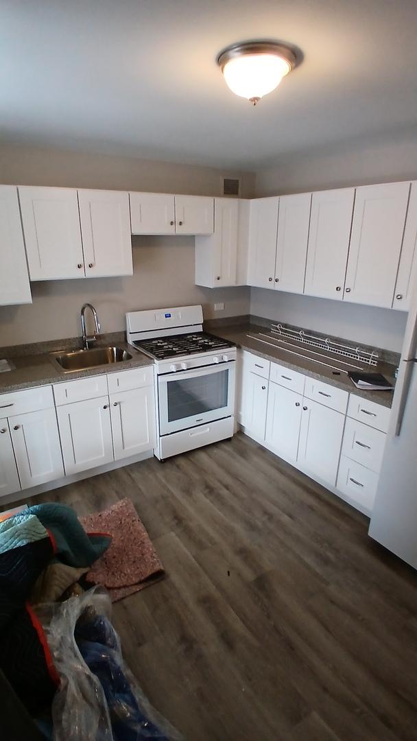 4850 S Lake Park Ave Unit 1409, Chicago, IL 60615 - kitchen with white appliances, a sink, dark wood-style flooring, and white cabinets