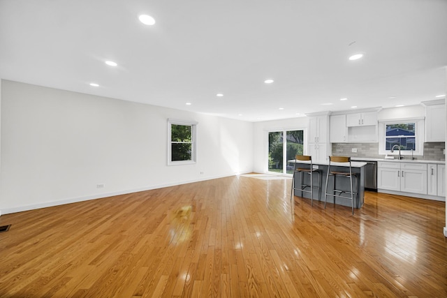 3795 Whispering Trails Dr, Hoffman Estates, IL 60192 - unfurnished living room with light wood-style flooring, recessed lighting, a sink, and baseboards