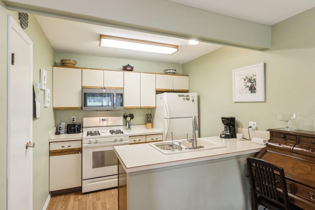 903 Wiltshire Dr Unit S2, Mchenry, IL 60050 - kitchen with white appliances, a peninsula, a sink, light wood-style floors, and light countertops