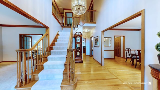 1420 Greenlake Dr, Aurora, IL 60502 - stairway with a chandelier, a high ceiling, ornamental molding, and wood finished floors
