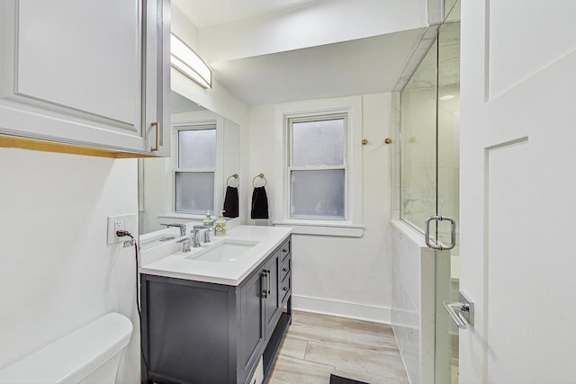 1049 Fowler Ave, Evanston, IL 60202 - bathroom featuring wood finished floors, vanity, a shower stall, toilet, and baseboards