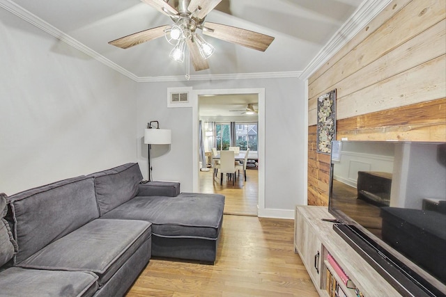 1049 Fowler Ave, Evanston, IL 60202 - living room with a ceiling fan, wooden walls, light wood-type flooring, crown molding, and baseboards