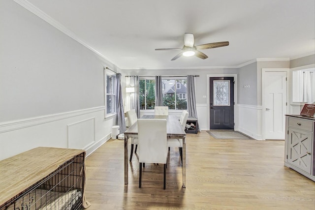 1049 Fowler Ave, Evanston, IL 60202 - dining space featuring a ceiling fan, a wainscoted wall, ornamental molding, light wood-style floors, and a decorative wall