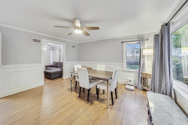 1049 Fowler Ave, Evanston, IL 60202 - dining room with ceiling fan, light wood-style floors, wainscoting, and crown molding
