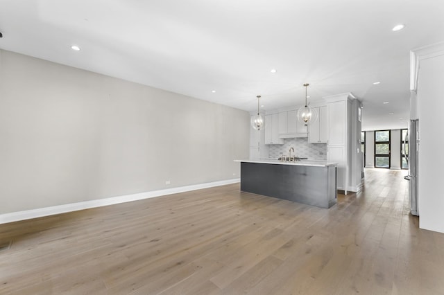 3406 N Keating Ave, Chicago, IL 60641 - kitchen with light wood-style floors, light countertops, recessed lighting, backsplash, and white cabinets
