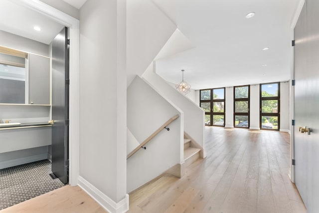 3406 N Keating Ave, Chicago, IL 60641 - hallway with light wood-style floors, recessed lighting, a wall of windows, and a chandelier