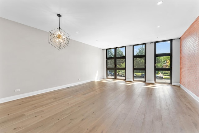 3406 N Keating Ave, Chicago, IL 60641 - unfurnished room with light wood-style floors, floor to ceiling windows, a chandelier, and recessed lighting