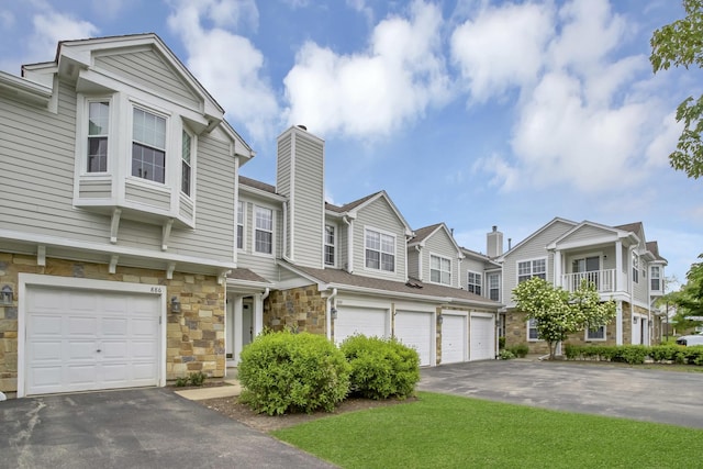 886 Ann Arbor Ln, Vernon Hills, IL 60061 - townhome / multi-family property with an attached garage, stone siding, driveway, a chimney, and a residential view