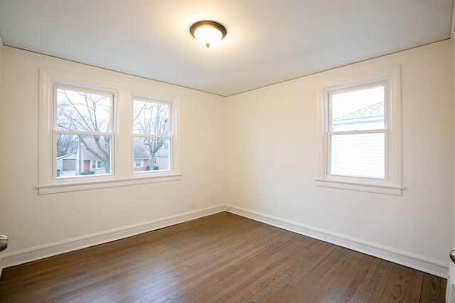 9237 S Utica Ave, Evergreen Park, IL 60805 - empty room featuring dark wood-type flooring, healthy amount of natural light, and baseboards