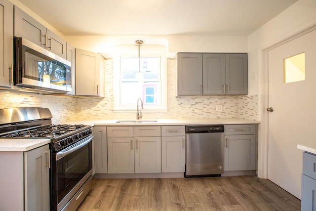 9237 S Utica Ave, Evergreen Park, IL 60805 - kitchen featuring appliances with stainless steel finishes, a sink, gray cabinetry, decorative backsplash, and light countertops