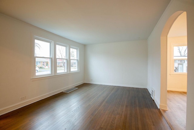9237 S Utica Ave, Evergreen Park, IL 60805 - empty room featuring arched walkways, dark wood finished floors, and baseboards