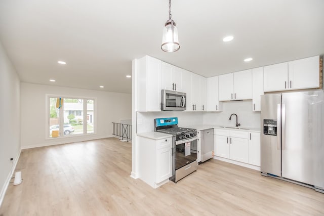 4237 Arlington Dr, Richton Park, IL 60471 - kitchen with stainless steel appliances, a sink, light countertops, light wood finished floors, and white cabinets