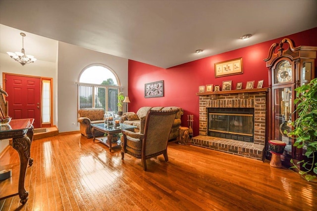 16308 S Peerless Ct, Plainfield, IL 60586 - living area with hardwood / wood-style floors, a brick fireplace, a chandelier, and baseboards