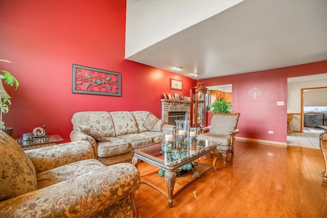 16308 S Peerless Ct, Plainfield, IL 60586 - living area with wood finished floors, a brick fireplace, and baseboards