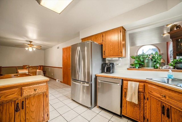 16308 S Peerless Ct, Plainfield, IL 60586 - kitchen with appliances with stainless steel finishes, light countertops, brown cabinets, ceiling fan, and light tile patterned floors