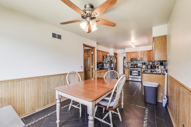 5560 W Ardmore Ave, Chicago, IL 60646 - dining room with a wainscoted wall, a ceiling fan, and wooden walls