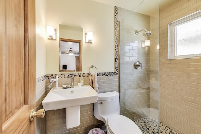 5560 W Ardmore Ave, Chicago, IL 60646 - bathroom with tile walls, toilet, a tile shower, wainscoting, and ceiling fan