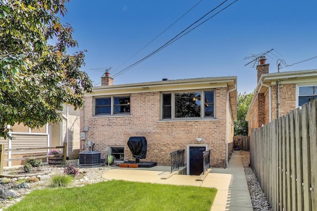 5560 W Ardmore Ave, Chicago, IL 60646 - rear view of property with a chimney, brick siding, a fenced backyard, and central air condition unit