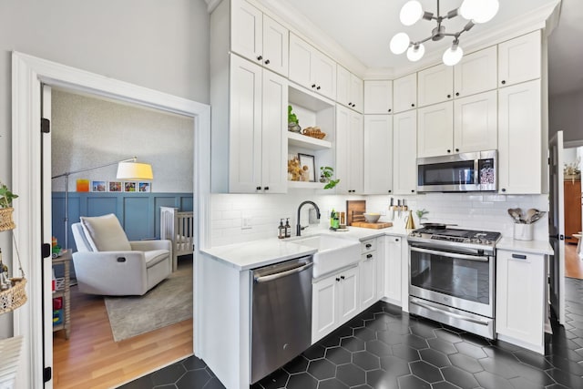 2149 N Seminary Ave Unit A, Chicago, IL 60614 - kitchen with appliances with stainless steel finishes, a sink, open shelves, light countertops, and a chandelier