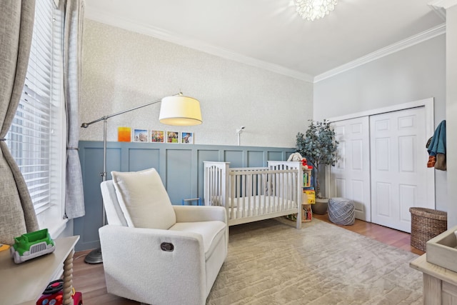 2149 N Seminary Ave Unit A, Chicago, IL 60614 - bedroom featuring ornamental molding, wood finished floors, a crib, a decorative wall, and a closet