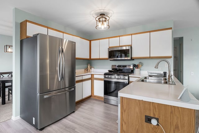 1585 Belle Haven Dr, Grayslake, IL 60030 - kitchen featuring appliances with stainless steel finishes, a sink, light countertops, light wood-style floors, and white cabinets