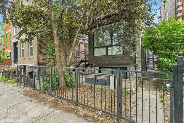 921 N Honore St Unit B, Chicago, IL 60622 - view of front of home featuring stairway, a fenced front yard, and brick siding