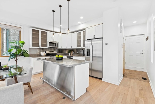 921 N Honore St Unit B, Chicago, IL 60622 - kitchen with appliances with stainless steel finishes, a sink, light wood finished floors, glass insert cabinets, and recessed lighting