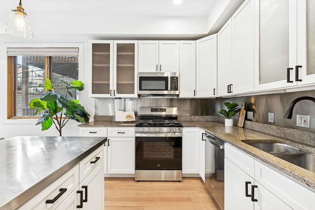 921 N Honore St Unit B, Chicago, IL 60622 - kitchen featuring appliances with stainless steel finishes, light wood-type flooring, a sink, white cabinetry, and recessed lighting
