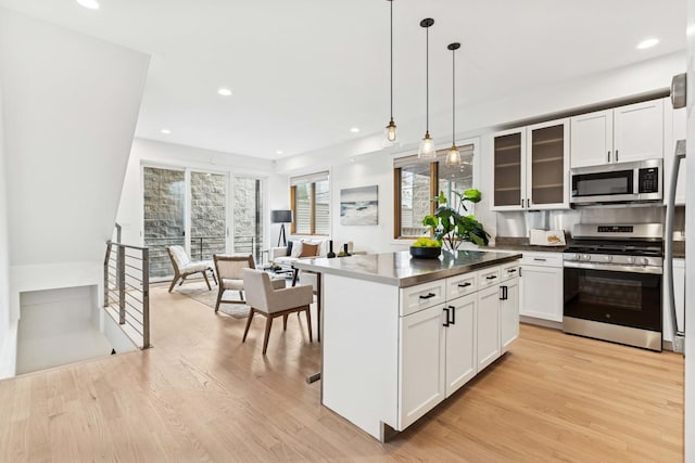 921 N Honore St Unit B, Chicago, IL 60622 - kitchen featuring appliances with stainless steel finishes, light wood finished floors, recessed lighting, white cabinetry, and glass insert cabinets