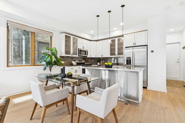 921 N Honore St Unit B, Chicago, IL 60622 - kitchen with appliances with stainless steel finishes, light wood-style flooring, baseboards, glass insert cabinets, and white cabinets