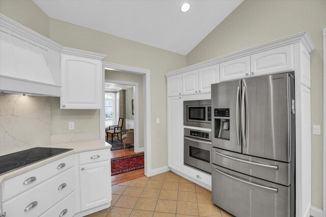 2502 Prairie Ridge Pl, Champaign, IL 61822 - kitchen with stainless steel appliances, white cabinetry, light countertops, custom range hood, and lofted ceiling