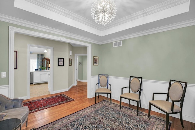 2502 Prairie Ridge Pl, Champaign, IL 61822 - living area featuring light wood-style floors, a chandelier, ornamental molding, and wainscoting