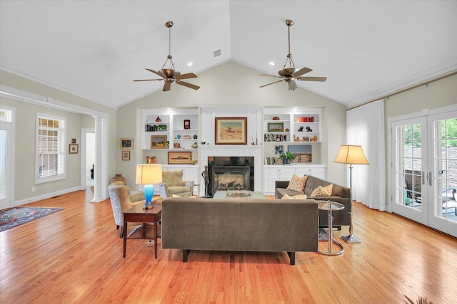 2502 Prairie Ridge Pl, Champaign, IL 61822 - living area with a ceiling fan, a glass covered fireplace, built in shelves, vaulted ceiling, and light wood finished floors