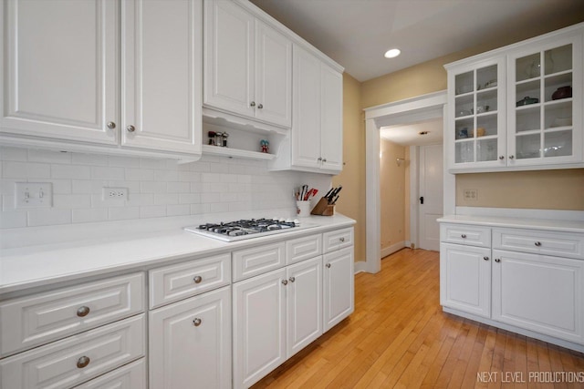352 Elm St, Batavia, IL 60510 - kitchen featuring white cabinets, backsplash, glass insert cabinets, light wood-style floors, and light countertops