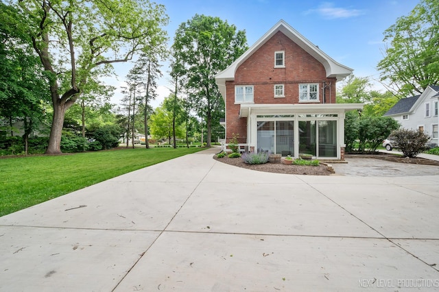 352 Elm St, Batavia, IL 60510 - back of property with brick siding, a lawn, and concrete driveway
