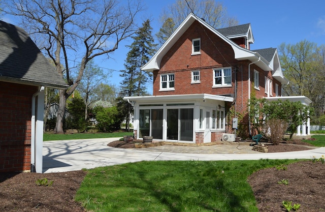 352 Elm St, Batavia, IL 60510 - rear view of house featuring a sunroom, brick siding, ac unit, a lawn, and a patio area
