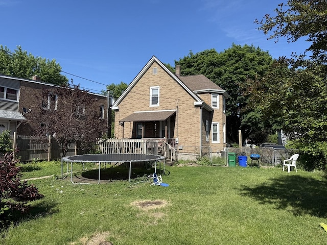 1711 S 4th St, Rockford, IL 61104 - rear view of house with a trampoline, brick siding, and a chimney