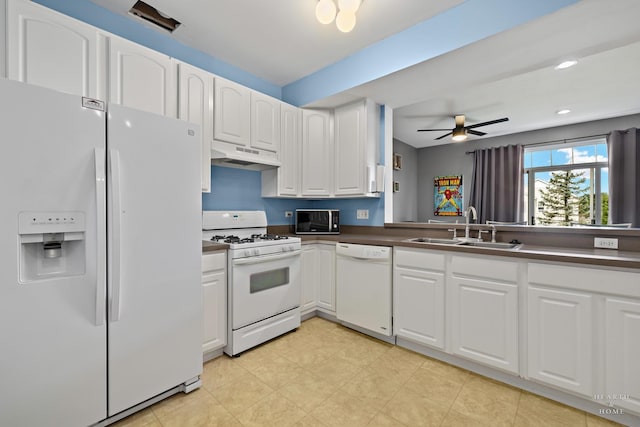 2015 Limestone Ln, Carpentersville, IL 60110 - kitchen featuring white appliances, a sink, under cabinet range hood, dark countertops, and white cabinetry