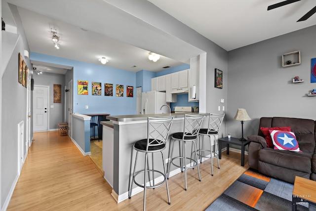 2015 Limestone Ln, Carpentersville, IL 60110 - kitchen featuring white refrigerator with ice dispenser, a peninsula, light wood-style flooring, and a breakfast bar area