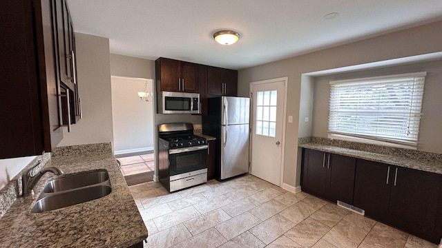 22500 Pleasant Dr, Richton Park, IL 60471 - kitchen featuring appliances with stainless steel finishes, a sink, dark brown cabinets, baseboards, and stone counters