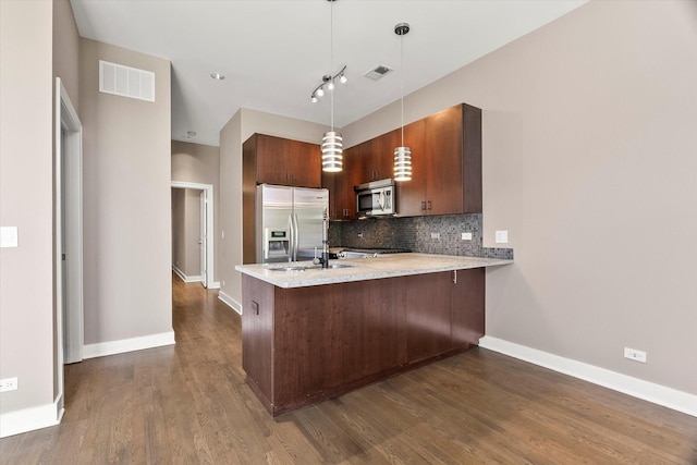 6 N May St Unit 403, Chicago, IL 60607 - kitchen featuring stainless steel appliances, a peninsula, tasteful backsplash, dark wood finished floors, and baseboards