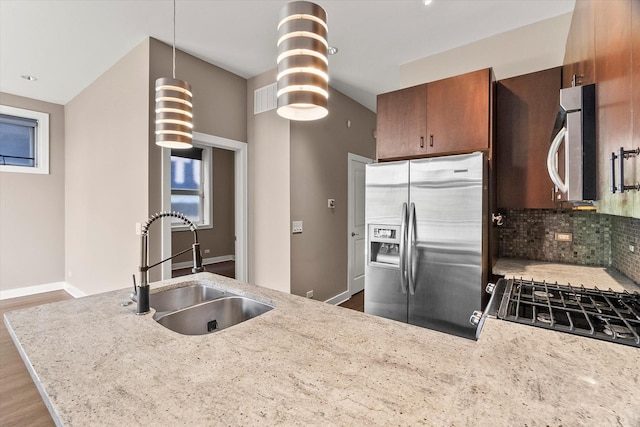 6 N May St Unit 403, Chicago, IL 60607 - kitchen with appliances with stainless steel finishes, a sink, brown cabinets, tasteful backsplash, and pendant lighting