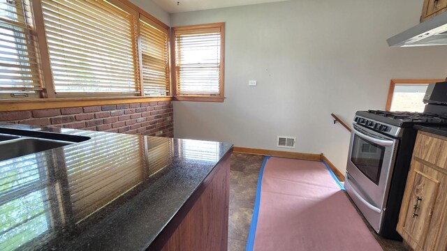 3544 Louis St, Franklin Park, IL 60131 - kitchen with gas range, under cabinet range hood, dark countertops, and baseboards
