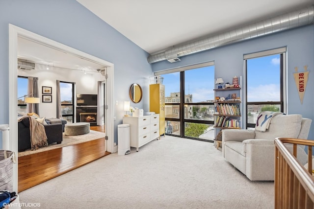 4020 N Damen Ave Unit 408, Chicago, IL 60618 - carpeted living area featuring track lighting, a wall mounted air conditioner, and a warm lit fireplace