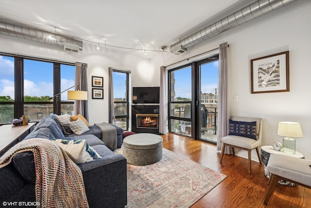 4020 N Damen Ave Unit 408, Chicago, IL 60618 - living area featuring wood finished floors, a warm lit fireplace, and track lighting